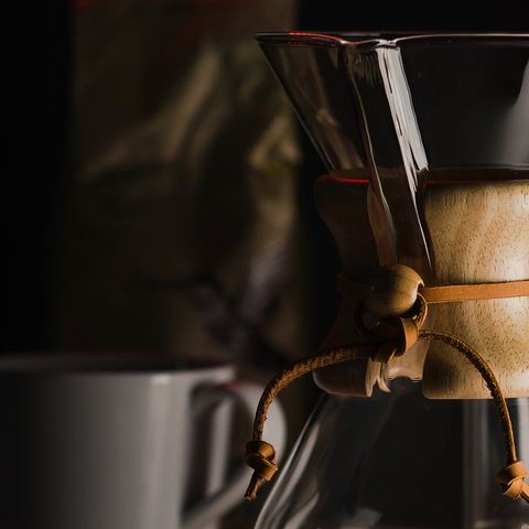 Pour-over coffee brewing in a glass Chemex (mood photo)